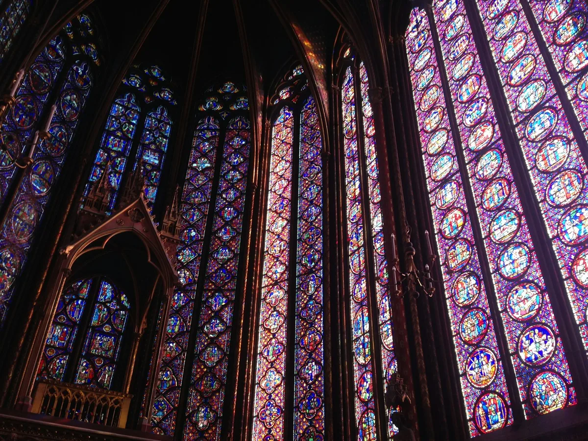Interior de catedral com vitrais coloridos e arquitetura gótica