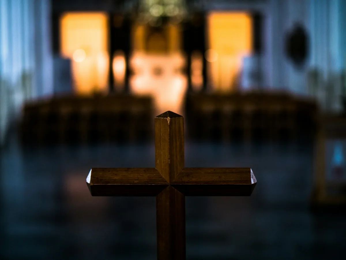 Cruz de madeira no interior de uma igreja iluminada