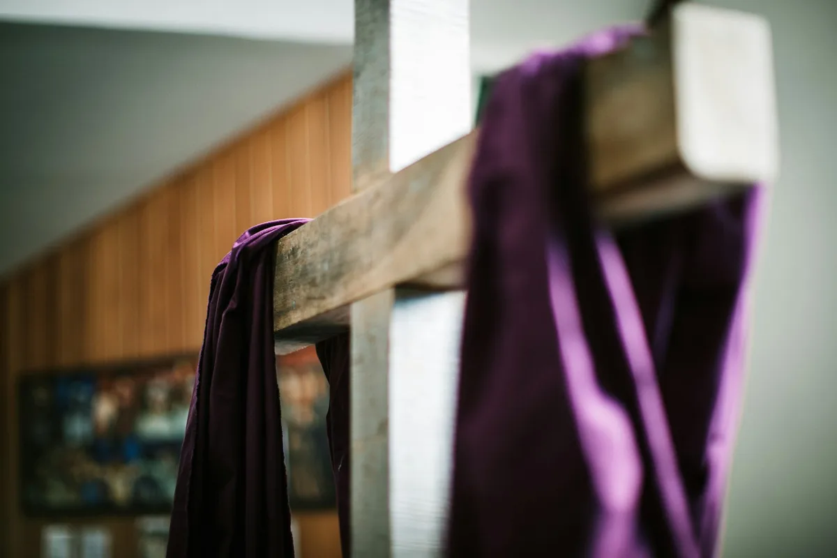 Uma simples cruz de madeira em uma igreja sob uma luz suave e acolhedora
