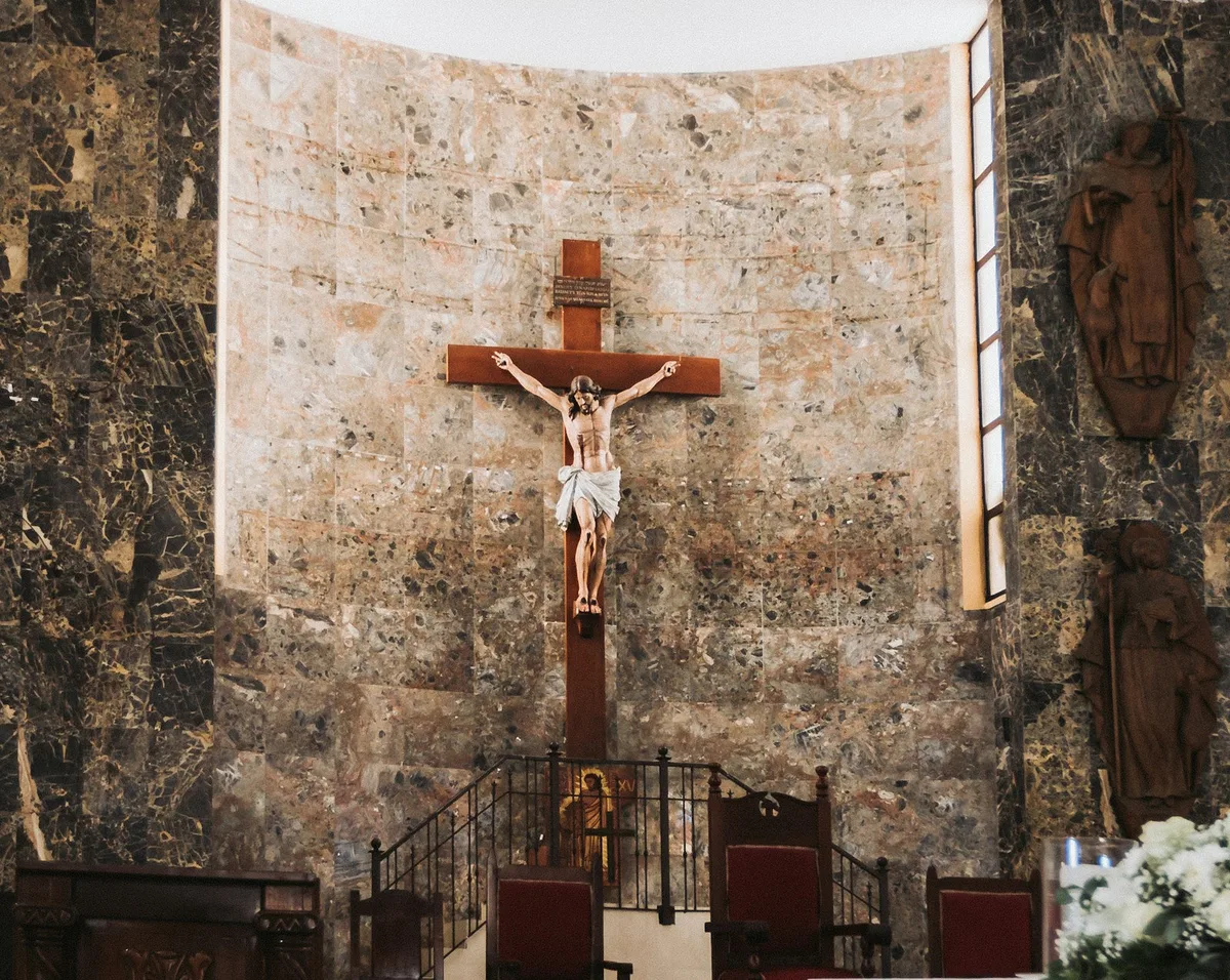 Cruz de madeira em uma igreja, em ambiente de oração silenciosa