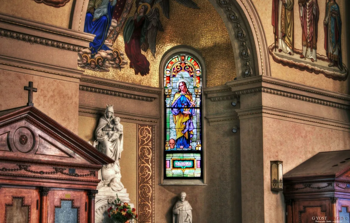 Vitral colorido com a imagem de um anjo em igreja católica
